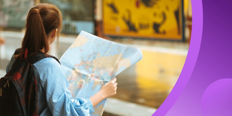 An international student with a backpack holding and looking at a world map while standing outdoors, with travel-themed background elements and a modern purple overlay on the right.