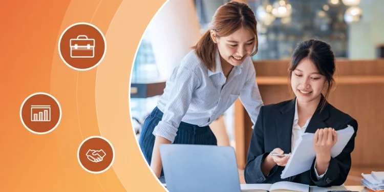 Two smiling professional women collaborating at an office desk with a laptop, reviewing documents together alongside career and business icons.